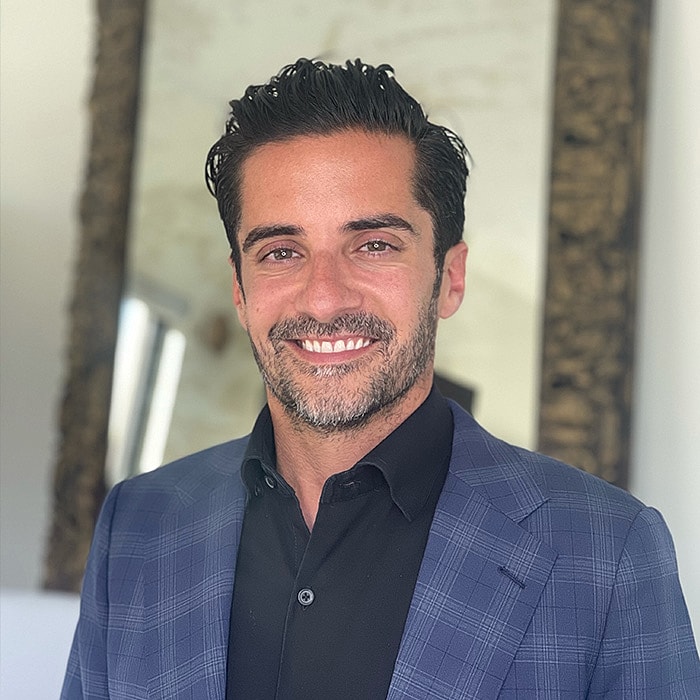 Smiling man in a blue suit jacket.