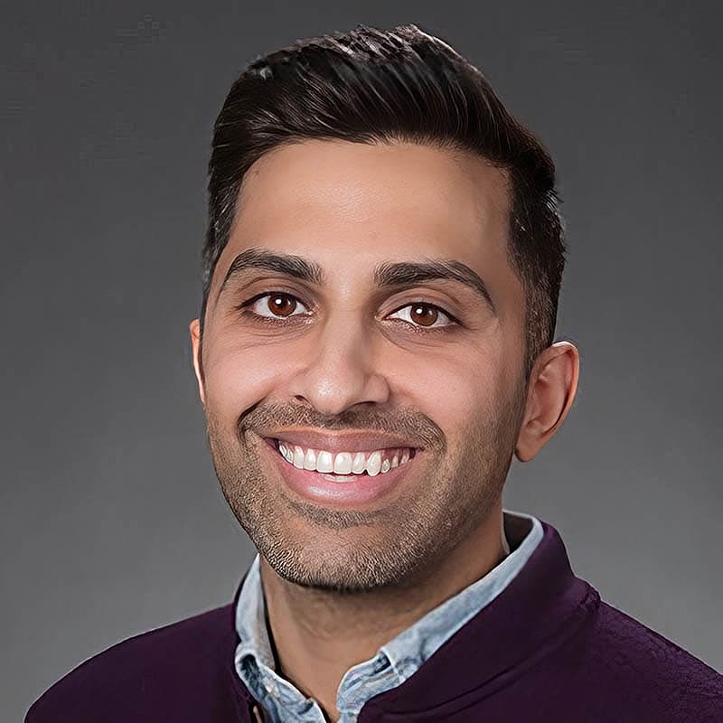 Smiling man with dark hair and beard.