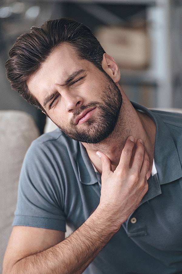 Man experiencing neck discomfort or pain.