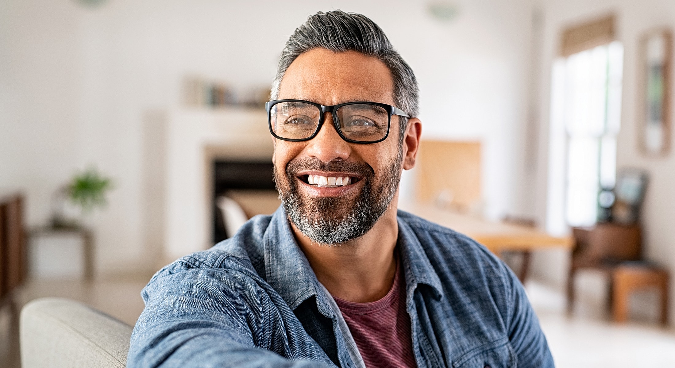 Smiling man in casual attire at home.