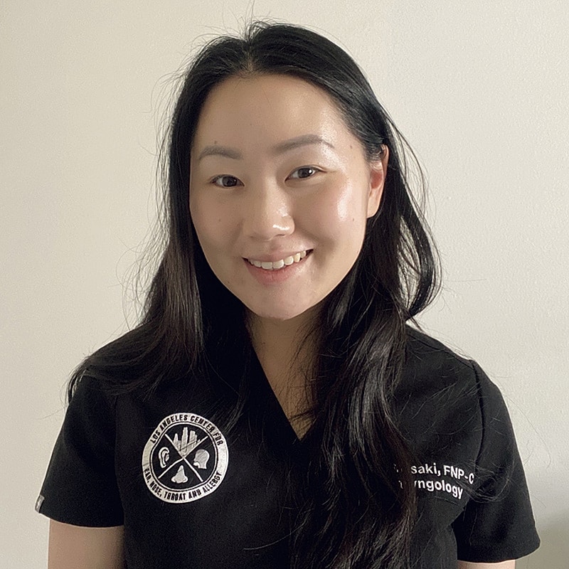Smiling healthcare professional in black scrubs.