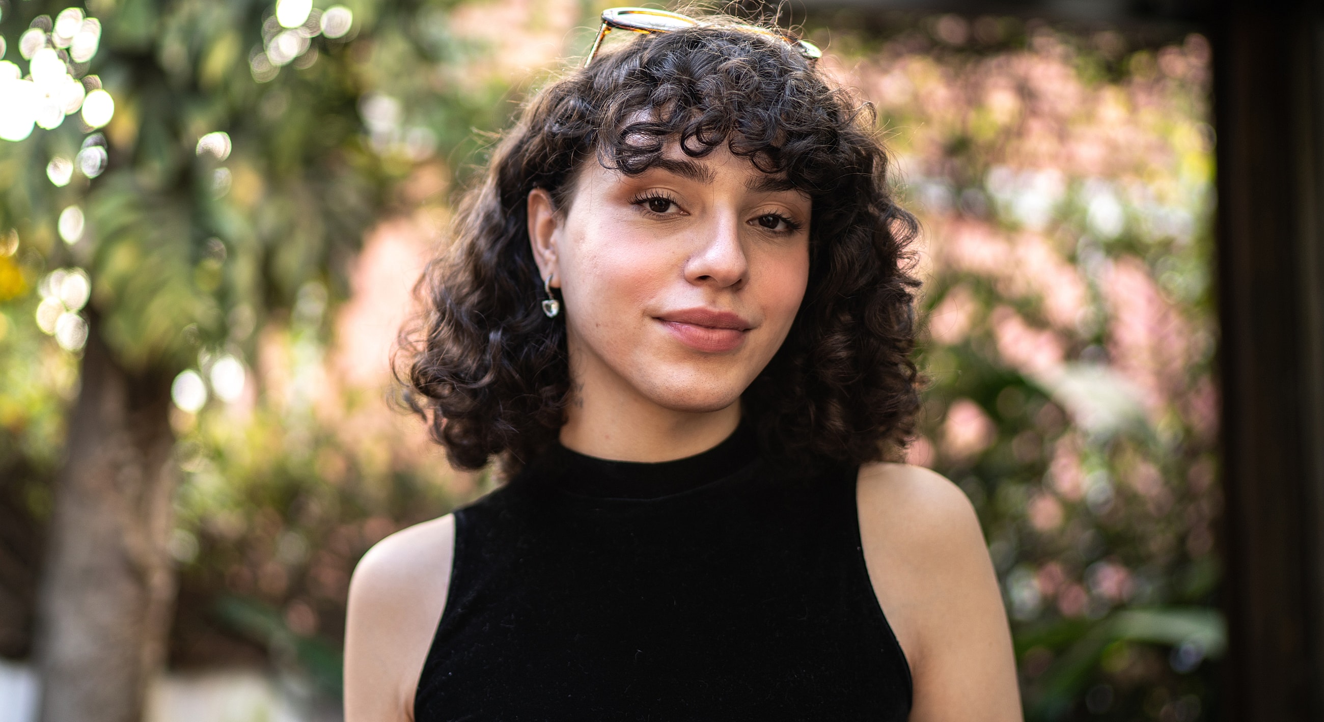 Person with curly hair wearing a black top.