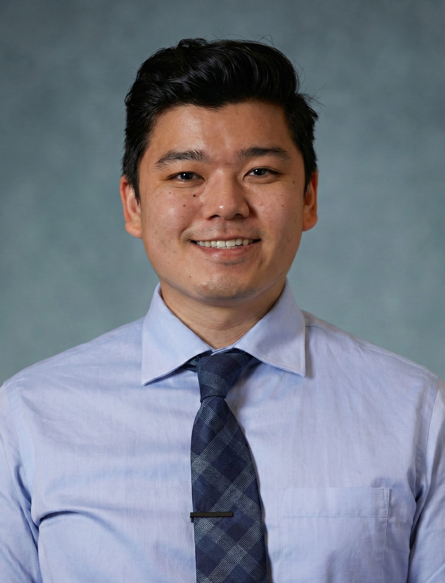 Smiling man in dress shirt and tie.