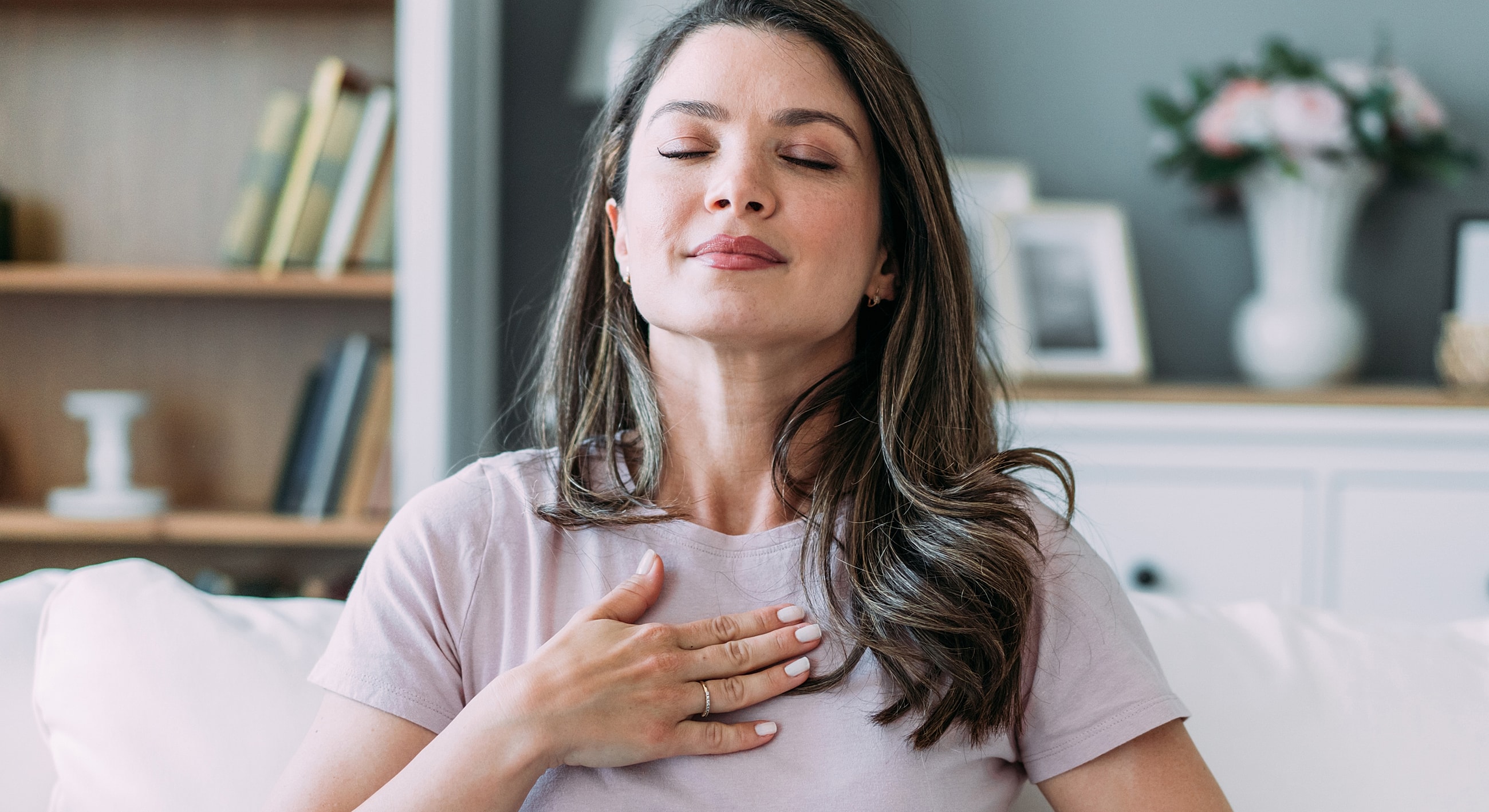 Woman practicing mindfulness and deep breathing indoors.