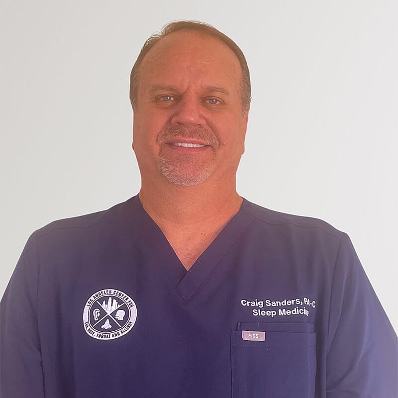 Medical professional in scrubs smiling for photo.