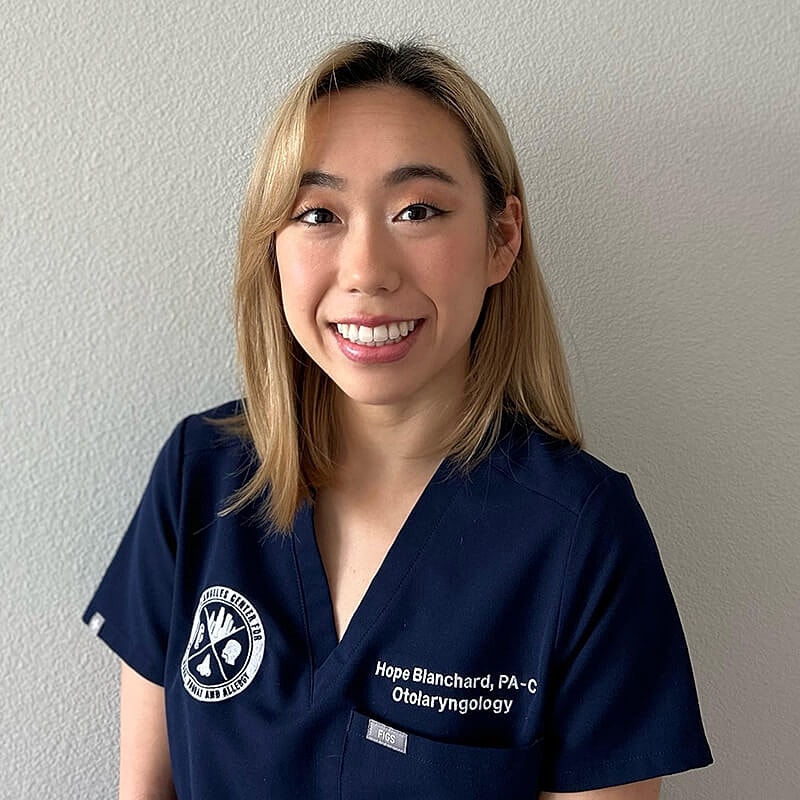 Smiling healthcare professional in medical attire.