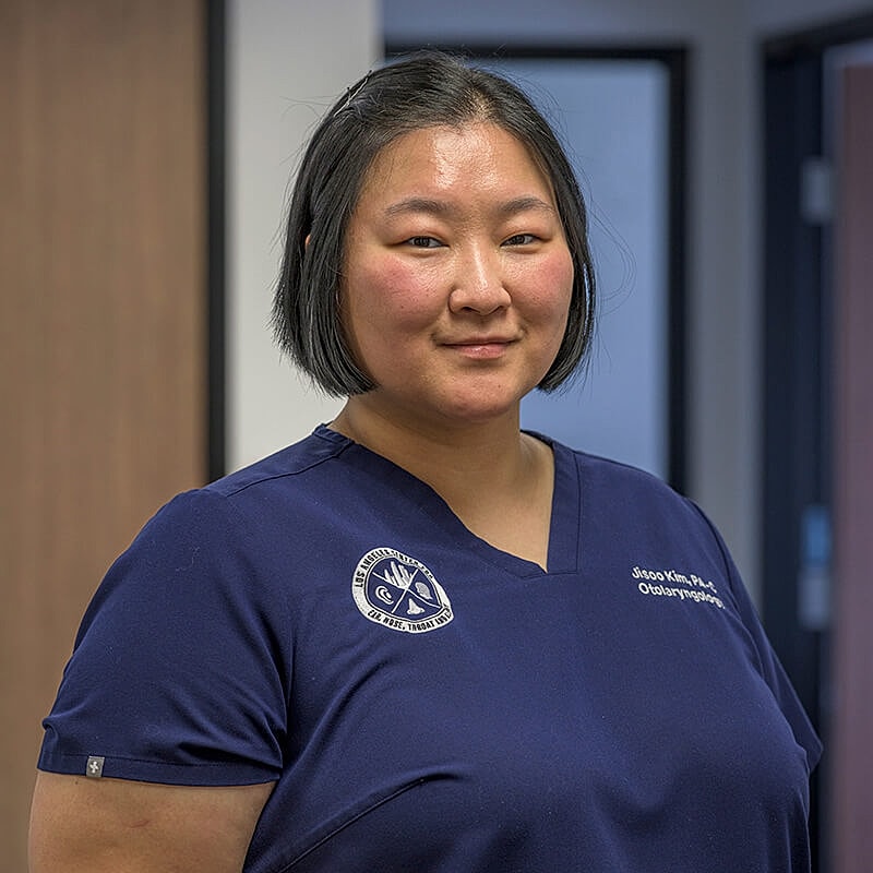 Female medical professional wearing scrubs indoors.