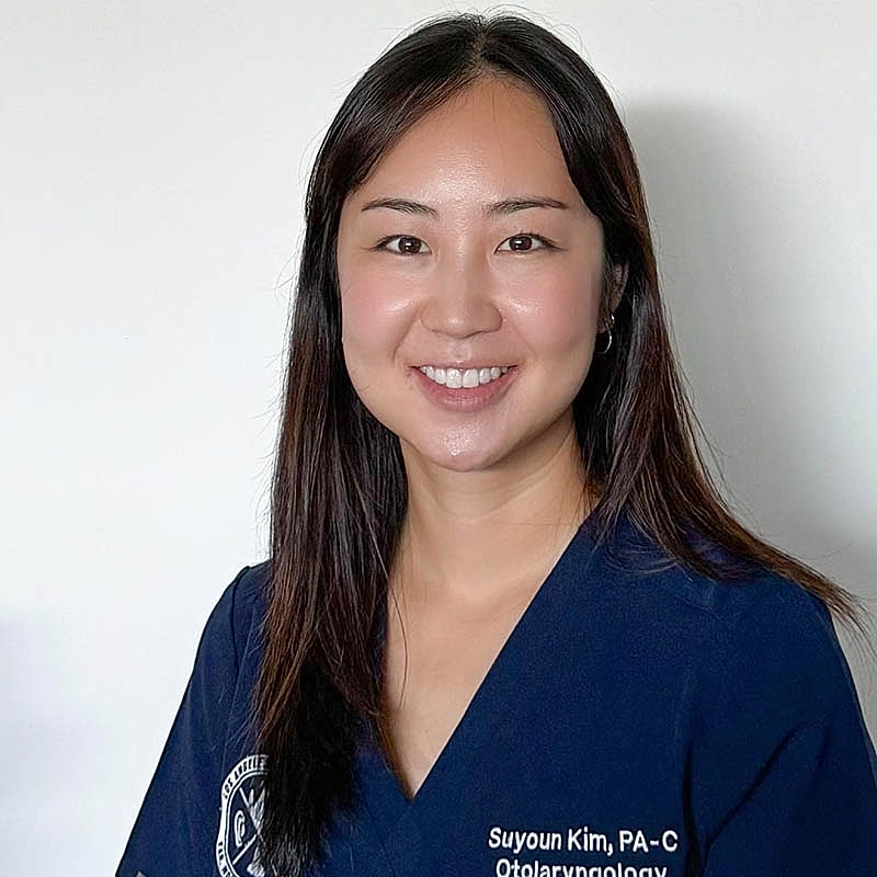 Smiling healthcare professional in medical attire.