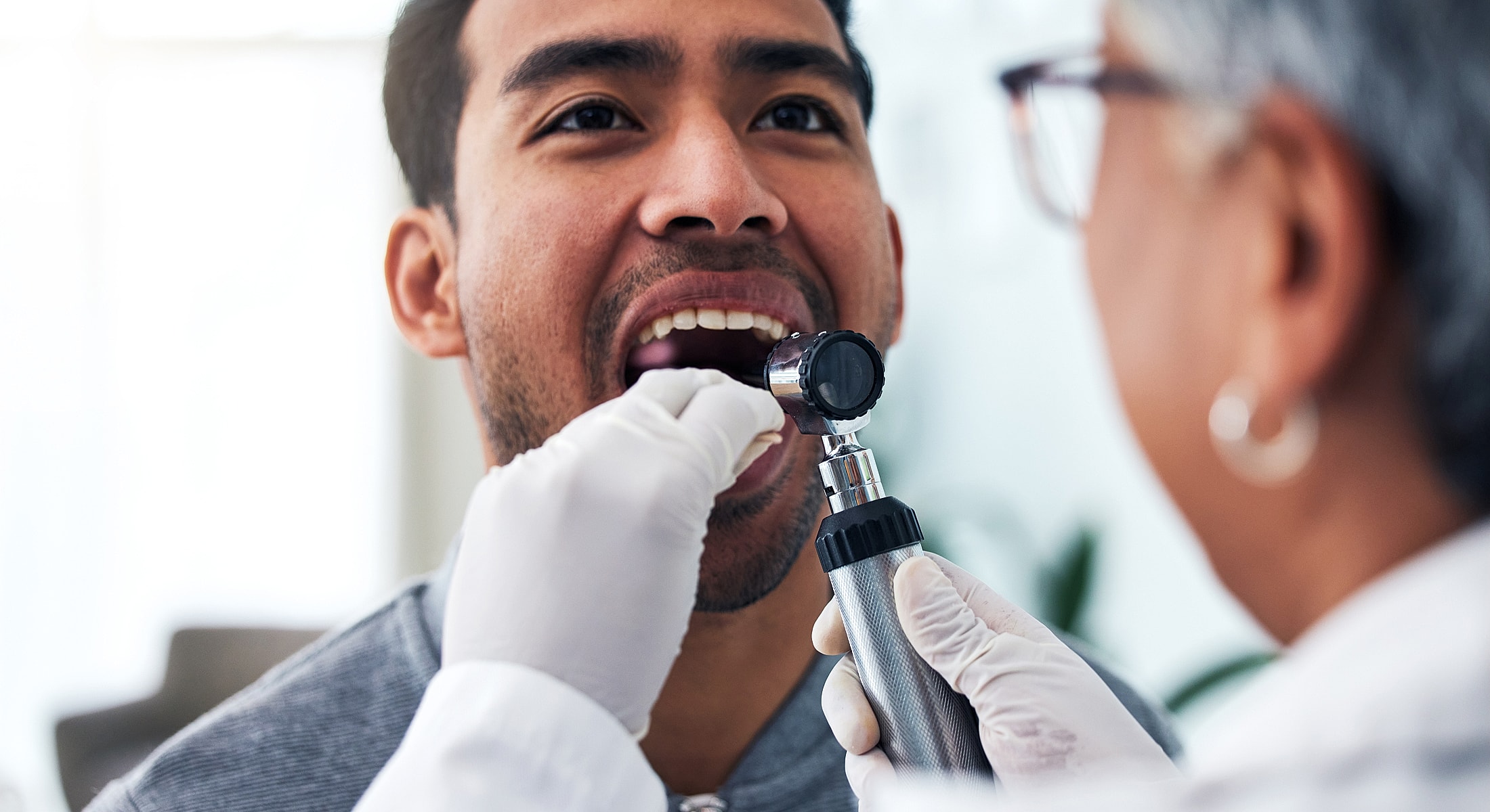 Patient receiving oral examination from healthcare professional.