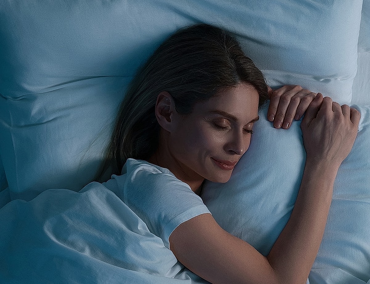 Woman peacefully sleeping in soft bedding.